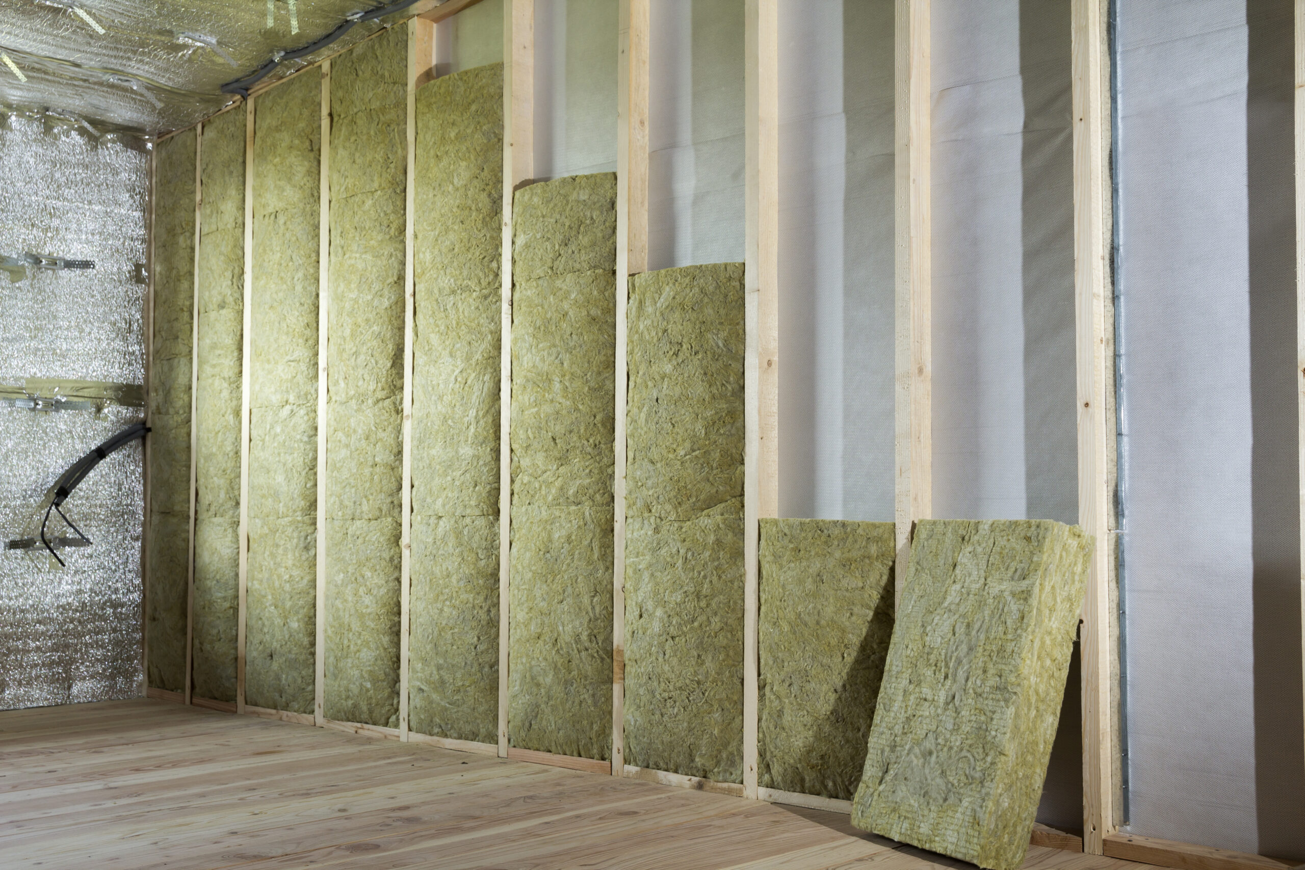 Wooden frame for future walls insulated with rock wool and fiberglass insulation staff for cold barrier. Comfortable warm home, economy, construction and renovation concept.
